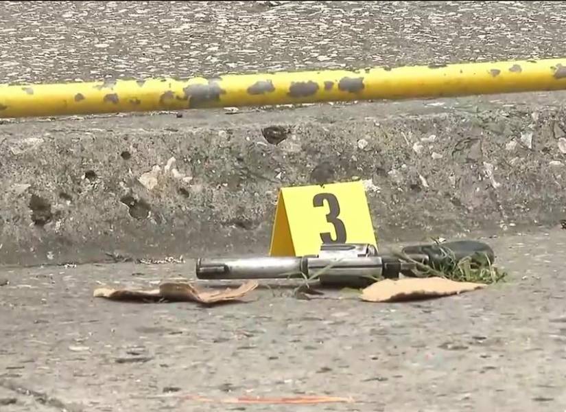 Imagen de un arma de fuego encontrada cerca del cuerpo del hombre abatido tras el asalto de un robo a la agencia de CNEL, en el norte de Guayaquil.