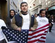 Imagen muestra a un grupo de personas participando en una manifestación pacífica en una calle urbana de Estados Unidos.