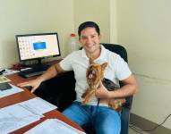 César Pinoargote en una foto en su oficina junto a su mascota.