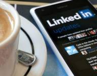 Imagen referencial de la aplicación LinkedIn con una taza de café al lado.