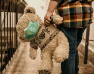 Imagen de un menor llevando a su peluche con mascarilla