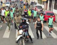 Uno de los sicarios, capturado por policías y militares, rodeados de jugadores de Liga de Portoviejo.