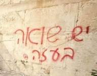 En la imagen se observa un grafiti realizado con aerosol rojo en el Muro de los Lamento.