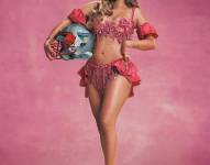 Karol G realizando el anuncio con un casco de fútbol americano.