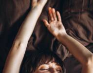 Mujer joven acostada en una cama