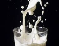 Imagen de sesión fotográfica de un vaso de leche siendo servido.
