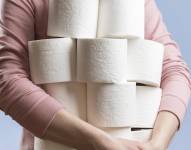 Imagen referencial de una persona llevando rollos de papel higiénico.