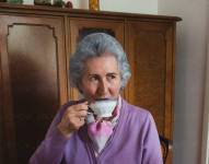 Señora de la tercera edad tomando café.