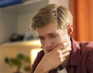 Hombre sosteniendo su celular mientras está preocupado.