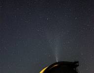 Foto de un telescopio con un cielo estrellado de fondo