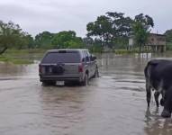 Imagen de un auto pasando por una zona inundada en Santa Lucía, Guayas.