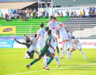 Jugadores del Delfín intentan despejar el balón
