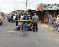 Imagen de personas rodeando el cuerpo de un bombero que fue asesinado esta mañana en Portoviejo.