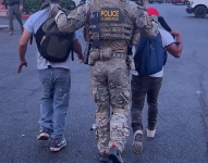 Un agente federal arrestando a dos hombres indocumentados