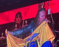 El vocalista de Maná, Fernando Olvera, sostiene la bandera de Ecuador.