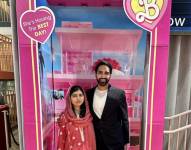 Malala Yousafzai y su esposo Asser Malik posando en una de las emblemáticas cajas de Barbie en el Reino Unido.