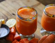 Imagen descriptiva de jugo de zanahoria con papaya en tabla de madera