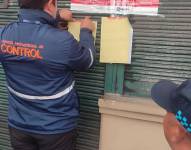 Momento en que los técnicoa de la AMC clausuran el local en Chillogallo.