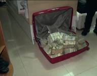 Imagen de una maleta llena de dinero encontrada en poder de una policía en un operativo en Daule, este viernes 15 de agosto.
