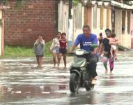 Personas caminando sobre calles anegadas, en Guayas.