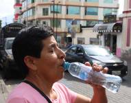 Foto referencial. Una mujer consume agua por el fuerte calor.