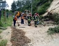 Obreros del Municipio de Quito limpian un deslizamiento de tierra.
