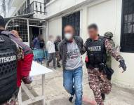 Imagen de un reo colombiano siendo trasladado a un bus, por personal penitenciario.