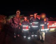 Los bomberos junto a los dos ciclistas rescatados.