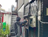 Un trabajador realiza una instalación para colocar un generador eléctrico en un bar del norte de Quito.