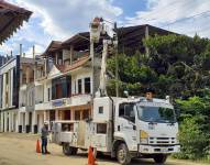 Un técnico realiza una revisión en un poste de alumbrado eléctrico.