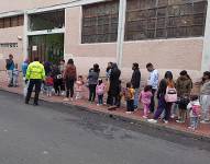 Padres de familia con sus hijos en el inicio de clases.