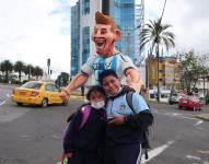 Dos niños posan junto a un monigote de Lionel Messi en Quito (Ecuador). EFE/Juan Francisco Chávez