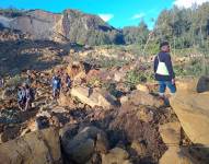 La gente camina con sus pertenencias en la zona de un deslizamiento de tierra (Kaokalam, provincia de Enga)