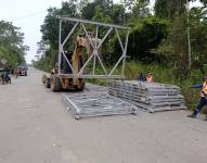Trabajadores instalan partes de un puente Bailey sobre el río Mollopongo.
