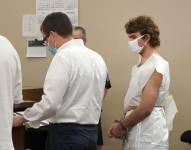 Payton Gendron habla con su abogado durante su comparecencia ante un juez, vistiendo una bata médica de papel, en la corte de Búfalo, el sábado 14 de mayo de 2022.