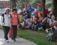 Una pareja observa varios muñecos de Año Viejo exhibidos para su venta en una calle de Quito.