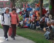 Una pareja observa varios muñecos de Año Viejo exhibidos para su venta en una calle de Quito.