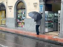 Un hombre camina con paraguas en la calle Olmedo del Centro Histórico durante la lluvia.