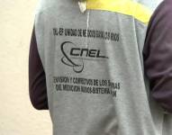 Imagen del logo de la Corporación Nacional de Electricidad (CNEL) en las prendas de un trabajador de la empresa.