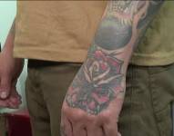 Imagen de una persona con parte de su brazo y mano tatuado.