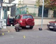 Un agente de Criminalística levanta evidencias junto al vehículo, tras el ataque armado.