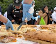 Personas preparan un pan con chicharrón en el distrito de Magdalena del Mar, en Lima (Perú). Foto de archivo.