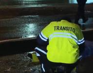 Imagen de un agente de tránsito en Vía a la Costa, indagando un siniestro donde falleció un motociclista.