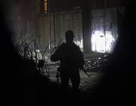 Combatientes palestinos de las Brigadas Izz ad-Din al-Qassam de Hamas custodian los vehículos del Comité Internacional de la Cruz Roja (CICR) que llegan para transportar los restos de rehenes israelíes entregados por Hamas en la ciudad de Gaza.