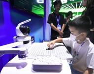 Imagen del 24 de agosto de 2024 de un niño jugando ajedrez con un robot en el área de exposiciones de la Cumbre Global de Emprendedores HICOOL 2024, en Beijing, capital de China.