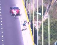 Foto de un ciclista pidiendo auxilio a otros ciudadanos para evitar que un ciudadano se suicide en Quito.