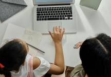 Imagen referencial para graficar cómo una madre guía a su hija en las tareas escolares.