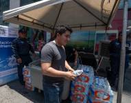 MEX7743. MONTERREY (MÉXICO), 14/06/2023.- Un hombre recibe una botella de agua entregada por integrantes de Protección Civil debido a las altas temperaturas que se registran hoy, en la ciudad de Monterrey (México). EFE/ Miguel Sierra