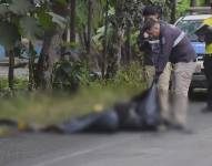 Imagen de un policía recogiendo cuerpos en la calle.