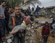 Palestinos recogiendo el cuerpo de un niño que se encontraba en los escombros de una casa destruida.